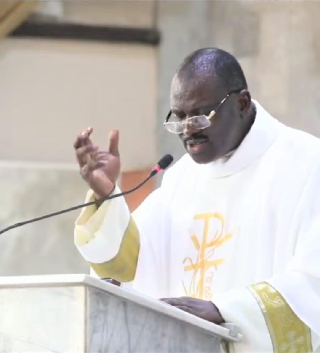 Padre Mike preaching from the ambo in white vestments