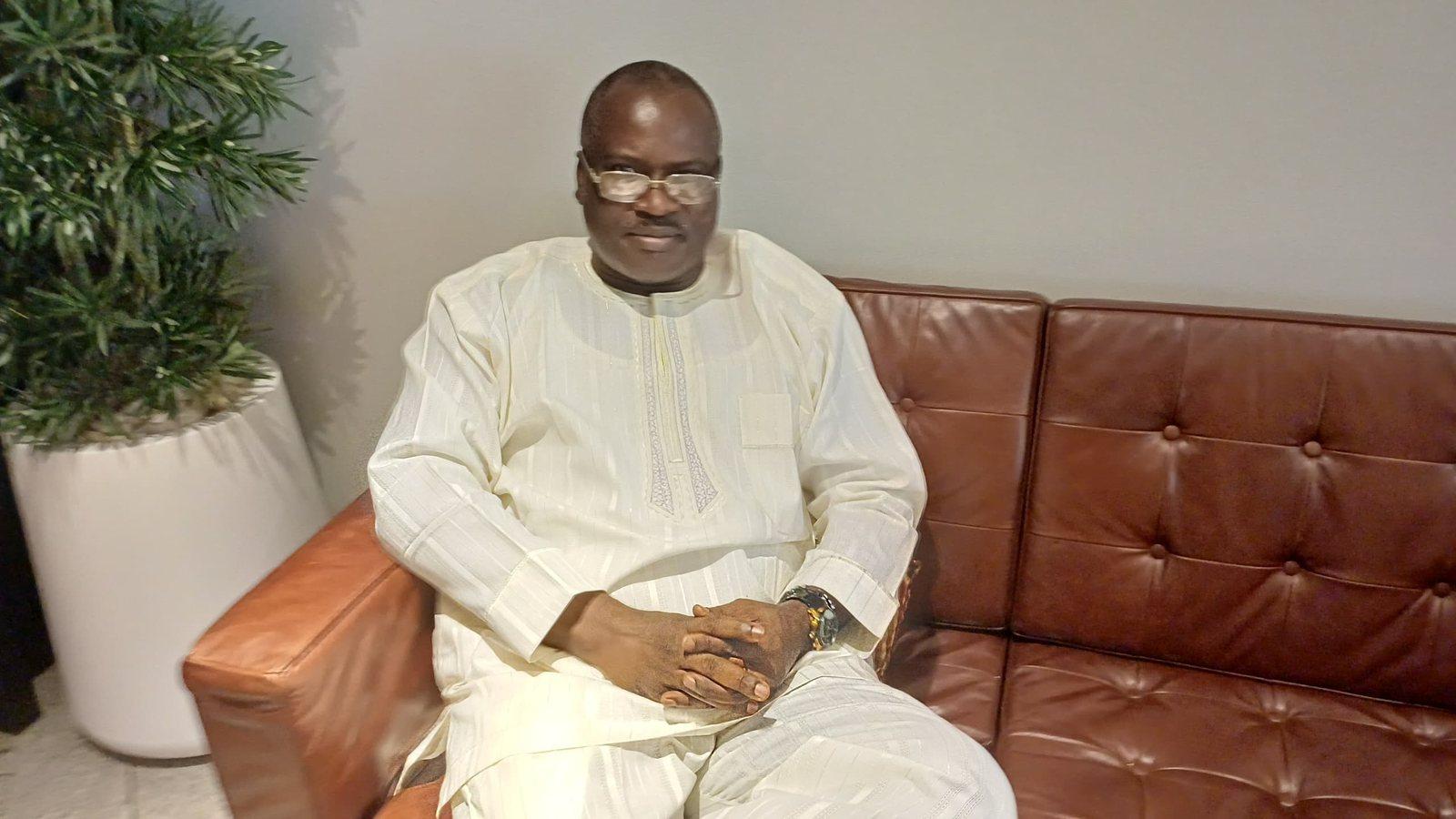 Padre Mike seated on a leather sofa